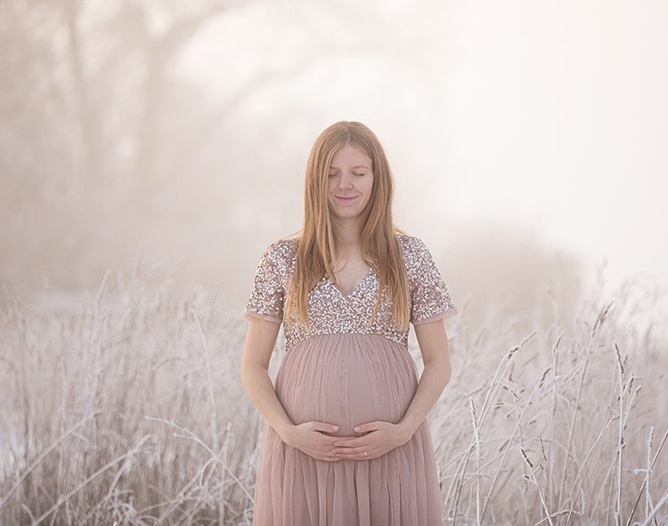 Mama in einem rosa-altrosa Tüllkleid mit Glitzer-Paillettenoberteil steht im Schnee und Nebel – Wintershooting Böblingen.