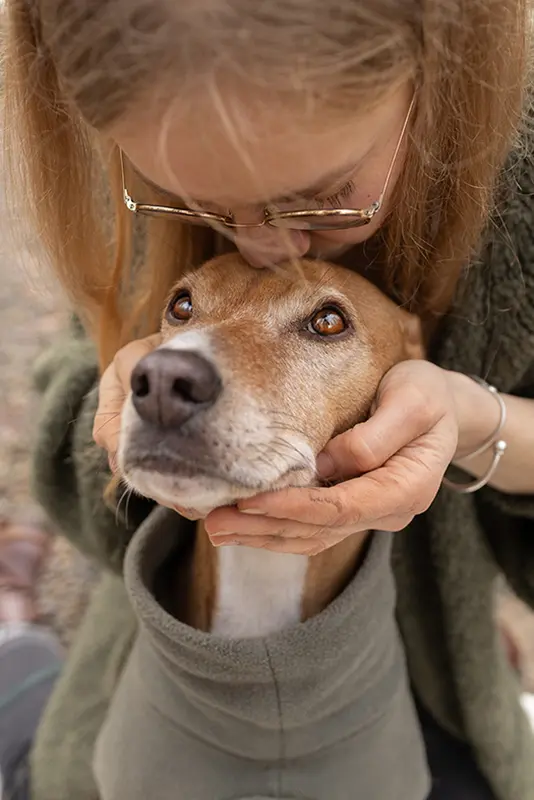 Frau hält liebevoll den Kopf ihres Hundes und küsst ihn auf die Stirn, bei einem Hunde Fotoshooting in Stuttgart